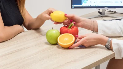 Consulenza nutrizionale: professionista e paziente valutano frutta e verdura.